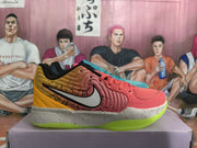 Side view of a coral and yellow basketball sneaker with a large swoosh, speckled midsole and bright green outsole, with a turquoise shoe partly visible behind it.