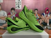 Angled view of the pair highlighting the green-and-black color scheme and outsole design.