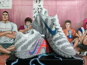 White and gray basketball shoes shown from the side, with blue and multicolor graphics and textured outsoles.