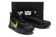 Black and gold sneaker pair displayed in front of a black shoebox.