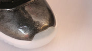 Detailed view of the rounded toe with dark metallic-look finish and white outsole.