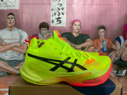 Side profile of a fluorescent green ASICS basketball shoe with black branding and orange detailing.