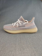 Side profile of a grey and pink-toned Yeezy 350 V2 style sneaker with a ribbed translucent gum-colored sole.