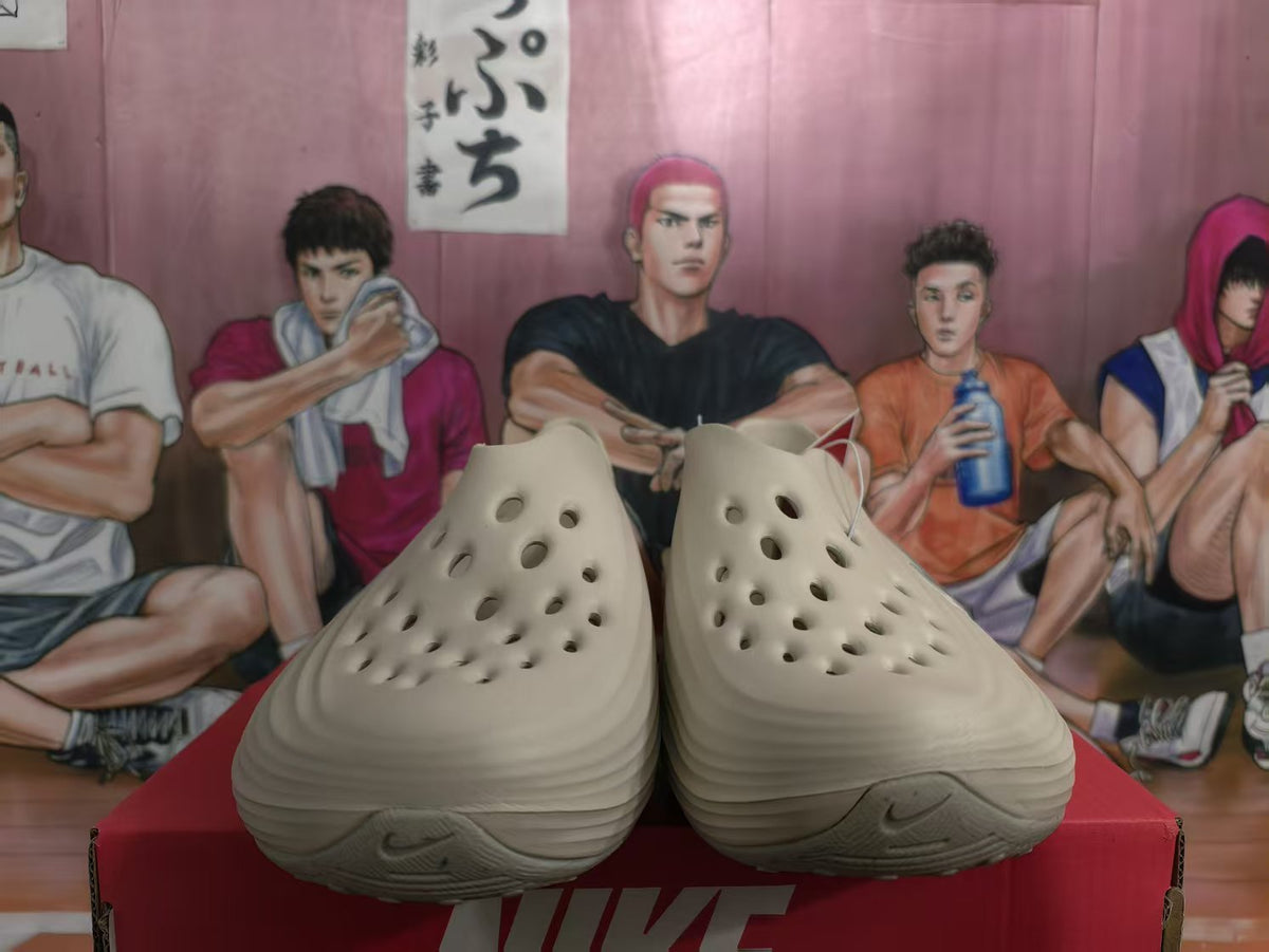 Front view of mocha brown perforated slip-on footwear resting on a red Nike box.