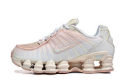 Side view of a white and pale pink Nike Shox TL sneaker.