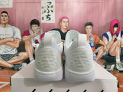 Rear view of a pair of white basketball sneakers showing heel pull tabs and ridged heel details