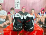 Rear view of the pair showing red TWELVE lettering, black textured uppers, white accents, and character artwork.