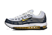 Side view of white, navy, and yellow Nike Air Max 97 OG sneakers.