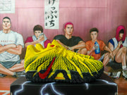Side profile of a yellow basketball shoe with black patterned panels, a red Nike swoosh, and a black textured outsole.