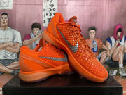 Pair of orange Nike basketball shoes with textured uppers and silver side Swooshes, shown at an angle.