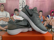 Angled product view of a pair of grey and black Nike KD basketball sneakers with visible Swoosh details, laces, tongue branding, and white outsoles.
