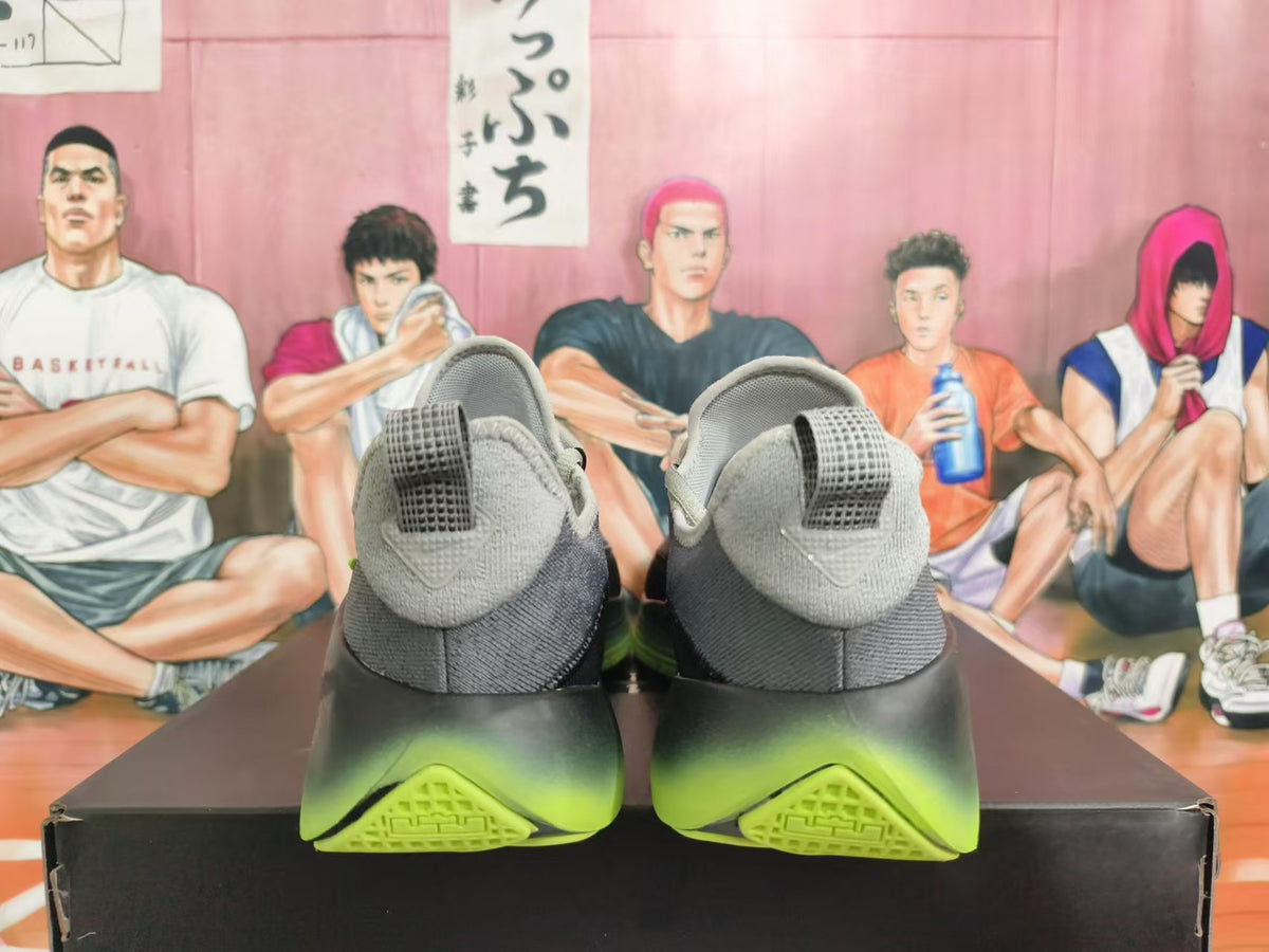 Rear view of gray Nike basketball shoes with black and volt-green soles.