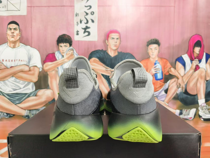 Rear view of gray Nike basketball shoes with black and volt-green soles.