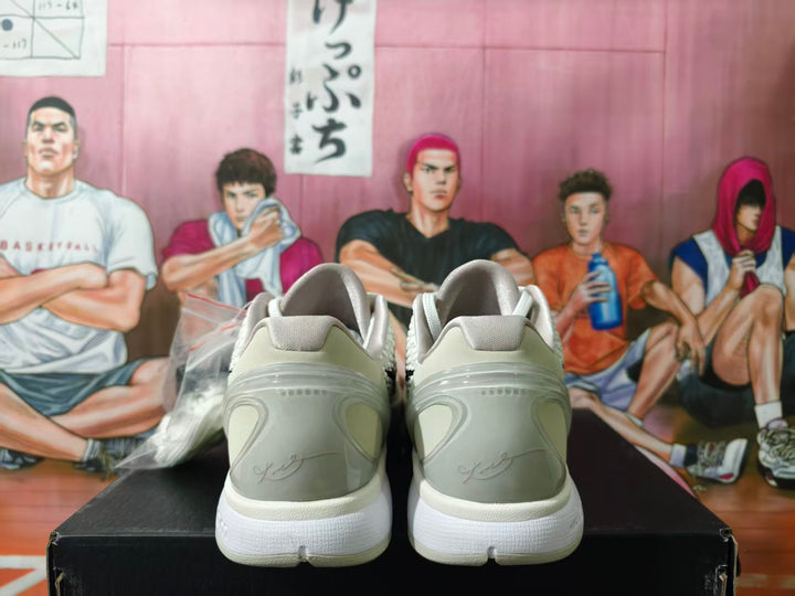 Rear view of off-white and gray Nike basketball sneakers with white soles.