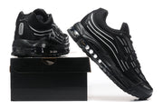 Pair of black sneakers with gray accents and visible sole cushioning, displayed with a black shoebox.
