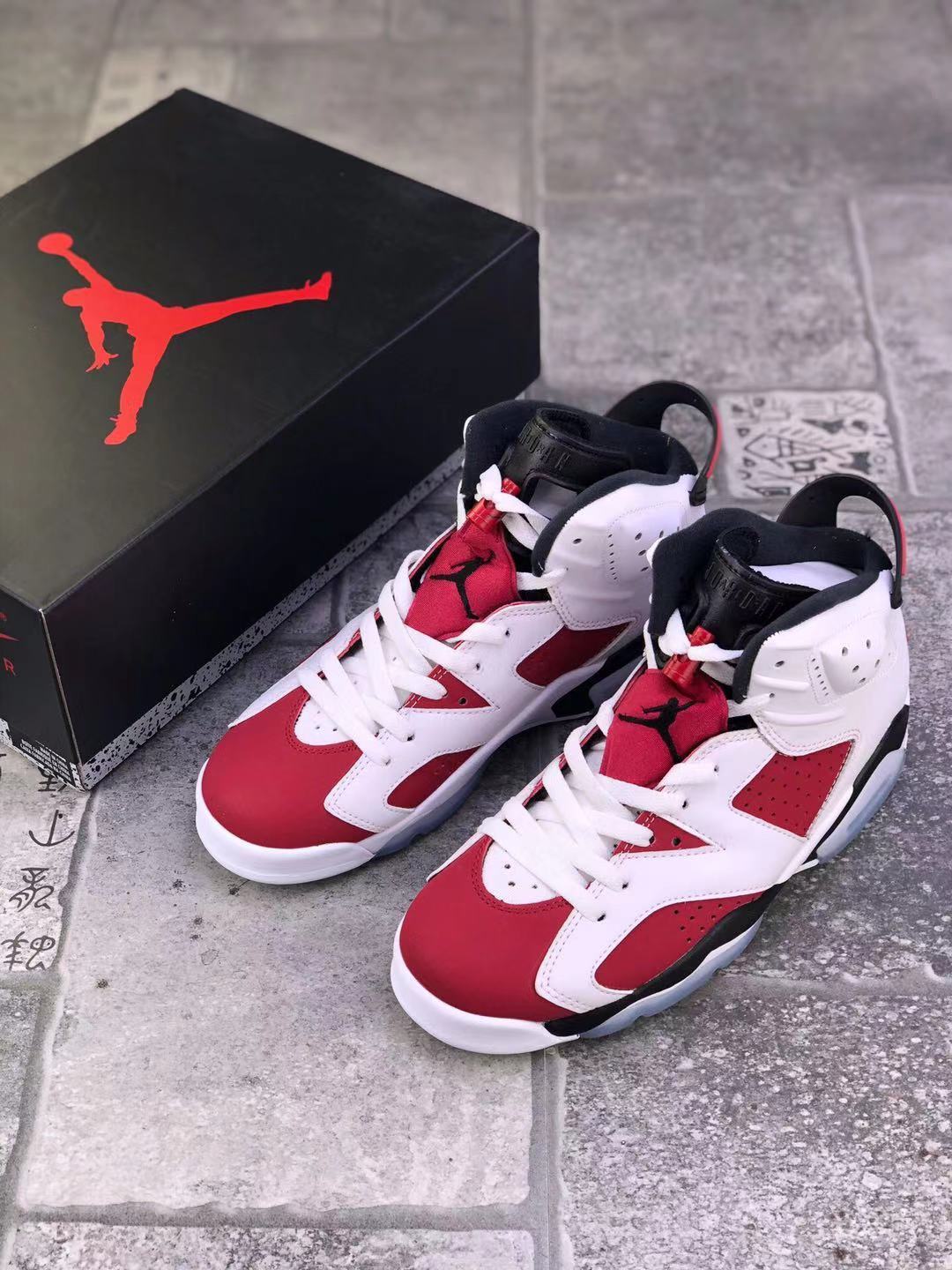 Pair of red, white, and black Jordan high-top sneakers shown beside a black Jordan shoe box.