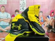 Angled view showing the textured black upper, yellow collar, side branding, and patterned outsole.