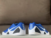 Rear view of the pair showing blue heel sections, white horizontal heel accents, black panels, and speckled midsoles.