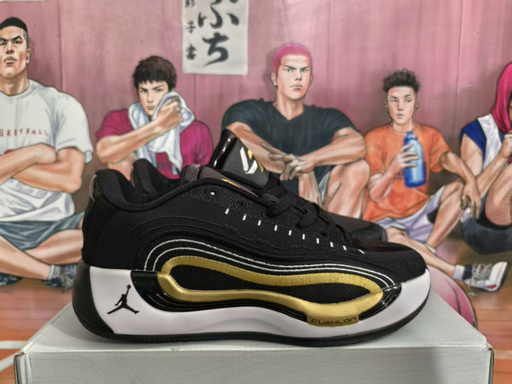 Side view of a black Jordan basketball sneaker with white and gold accents on a box.