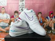 Pair of white low-cut basketball shoes with purple side detailing, shown from the side.