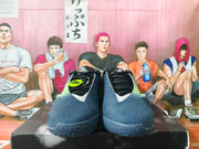 Front view of a pair of navy Nike basketball shoes with black laces and bright green accents.