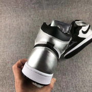Rear close-up showing the metallic silver heel, black collar, white midsole, and black outsole.