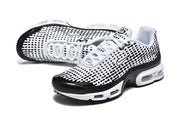 Angled view of white and black Nike sneakers with a dotted upper and visible air-cushion sole.