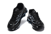 Front and top views of black Nike Shox R4 lace-up sneakers.