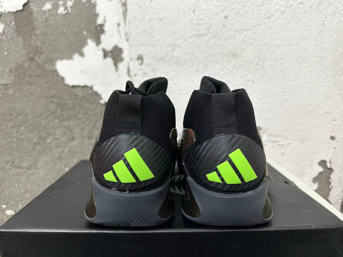 Rear view of black high-top basketball shoes with gray heel panels and bright lime-green Adidas marks.