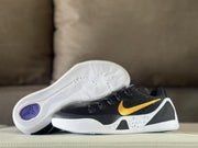 Black and gold basketball sneakers displayed with the white patterned outsole visible.