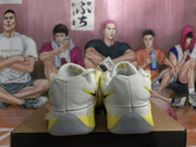 Rear view showing the heel panels and gray outsole of white and yellow Nike shoes