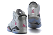 Rear and outsole view of the silver-gray high-top sneakers, showing pink heel branding, black heel details, and translucent blue soles.