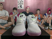 Front view of white KD basketball sneakers showing the laces, tongue logos, green accents, and purple outsoles.