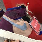 Close-up of the ankle area with a purple panel, light blue side logo, furry trim, and hangtag.