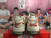 Rear view of cream Nike sneakers with red accents and cherry graphics