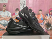 Pair of black and silver Nike GT basketball sneakers displayed on a box, showing the textured upper, side branding and layered outsole.