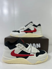 Side view of off-white, black, and red Jordan Jumpman Jack TR sneakers with a forefoot strap on a black box.