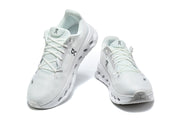 Angled top views of a pair of white On Cloudmonster 3 shoes.