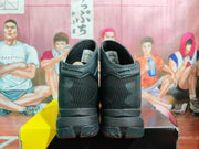 Rear view of the black and silver high-top sneakers, showing the padded collars, heel branding, and perforated ankle details.