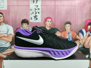 Side view of a black Nike basketball shoe with a white Swoosh and purple midsole accents