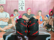 Rear view of the sneakers, showing black textured heel panels with red details and red lettering.
