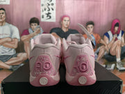 Rear view of the pink sneakers showing embroidered heel panels and circular heel emblems.