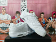 Angled side view of white sneakers showing perforated side panels, padded collars, heel cushioning details, and translucent outsole sections.