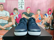 Front view of navy blue lace-up sneakers with black uppers and contrasting white soles.