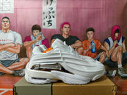 Side profile of a white sneaker with sculpted details and silver-tone accents