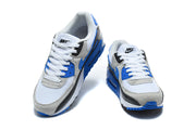 Front view of a pair of Nike Air Max 90 sneakers in white, grey, blue, and black.
