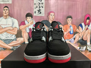 Front view of black basketball sneakers with Jumpman tongue logos, black laces, grey accents, and red outsoles.
