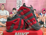 Angled view of a pair of red and black Nike sneakers highlighting the layered construction, heel details, and black toe caps.