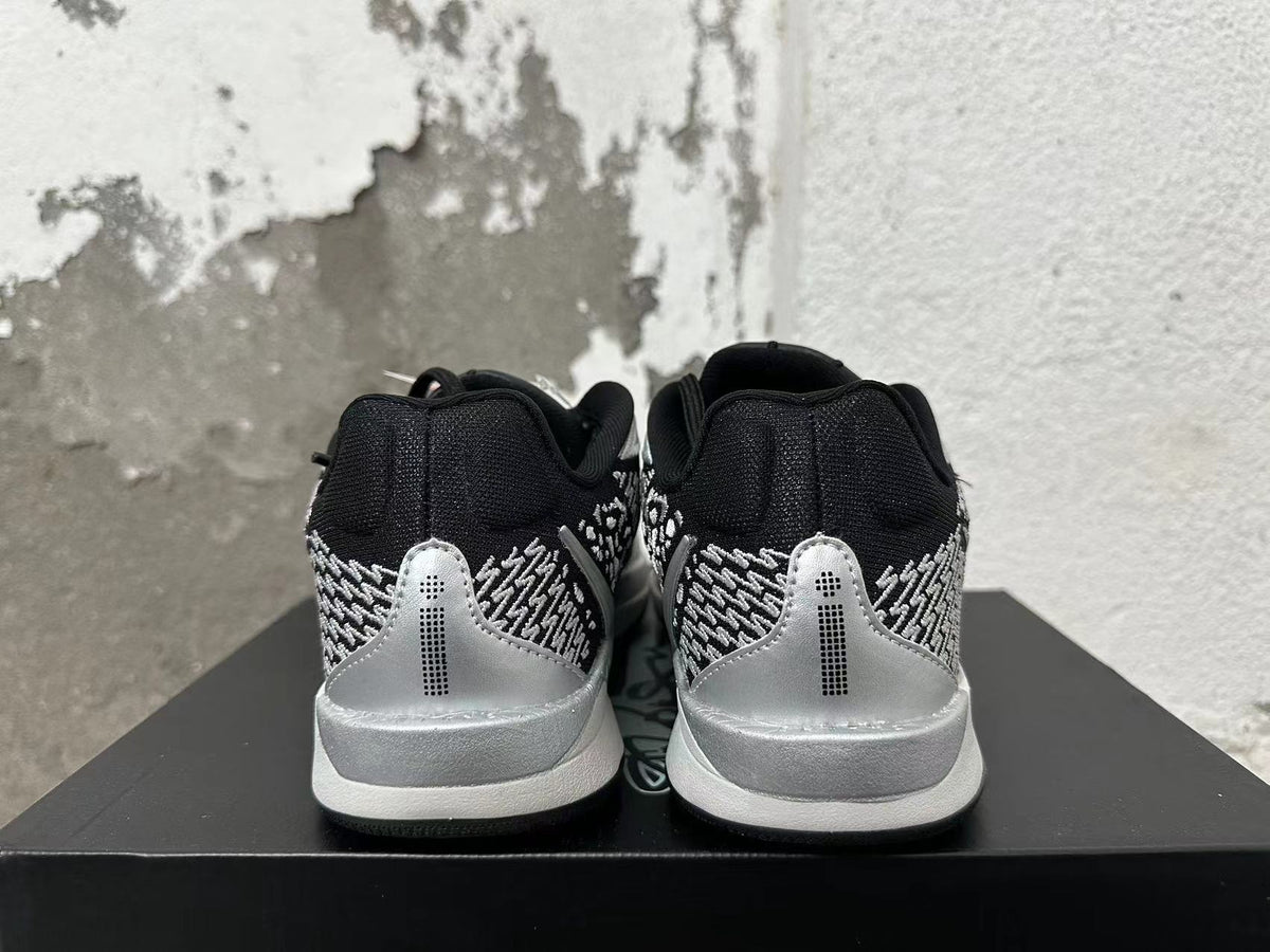 Rear view of black basketball shoes with silver heel panels and patterned detailing.