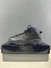 Side view of a black high-top Jordan sneaker with a purple collar and segmented outsole.